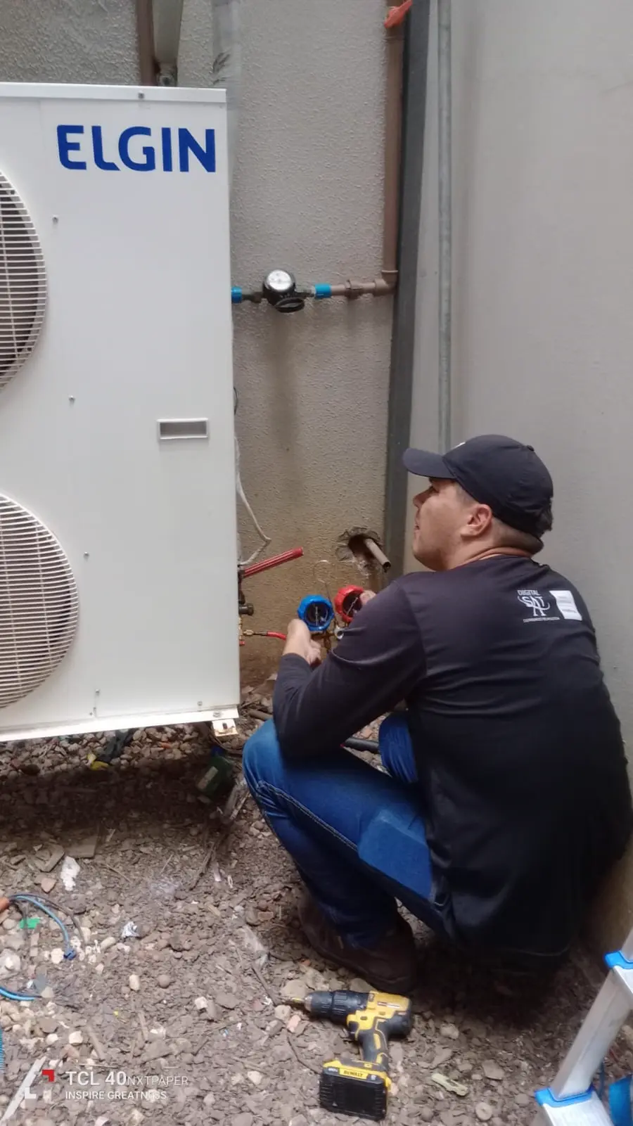 Técnico da Síntese Tecnologia instalando unidade de ar-condicionado